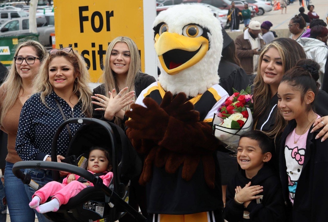 Family and friends of an HCC student pose for a photo with HCC mascot Swoop.